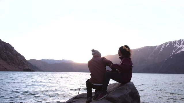 Video of a couple in love at the shore of a lake at sunset