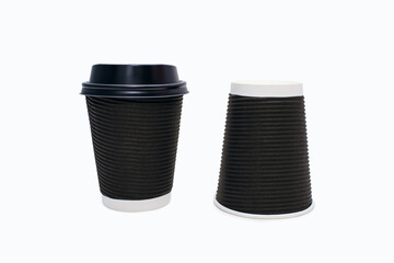 Two disposable black cardboard coffee cups on a white background. One coffee cup with plastic lid and one without. A variety of ways to drink coffee or tea from disposable cups