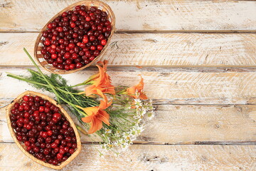 Summer cherry berries in baskets on a wooden background with daisies,wild flowers, harvesting in the village, the concept of healthy natural food, breakfast with ingredients, shop advertising