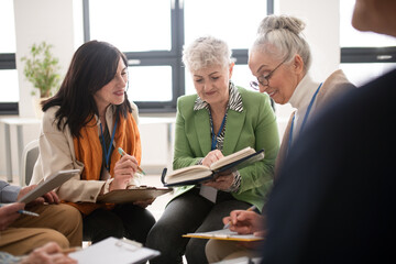Group of seniors with singing books together at choir rehearsal.