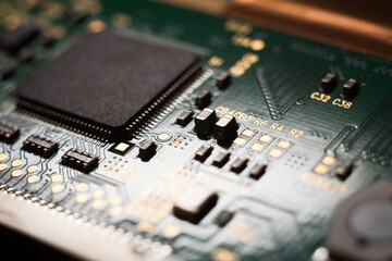 Macro photo of a green computer printed circuit board with selective focus on an blank chip. Concept photo. Microchip manufacturing in Taiwan.