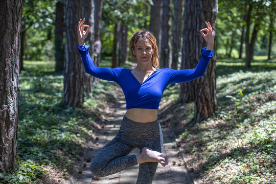 young woman performing yoga in forest
