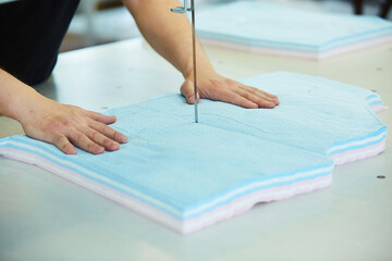 Cutting of fabrics on the machine. Industrial sewing production. A stack of fabrics