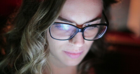 Young woman at night in the back seat of a car looking at cellphone