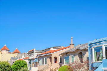 Fototapeta na wymiar Row of houses with with clay roof tiles against the clear blue sky in San Francisco, California