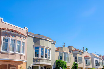 Row of painted houses with bow windows and clay tile roofs in San Francisco, CA