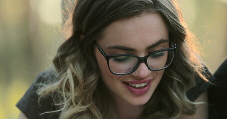 Portrait of blonde hispanic girl wearing glasses studying outside reading