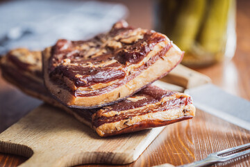 Whole smoked bacon on cutting board.