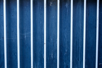 White Painted Security Bars Against A Blue Wooden Background