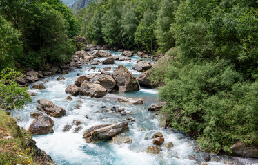 Naklejka na ściany i meble turquoise water river running down from the mountain