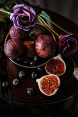 Low key still life with figs, blueberries and eustoma