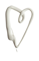 Heart shape made of white cream on a white background, can be used as mayonnaise too