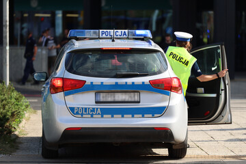 Radiowóz  polskiej policji państwowej podczas akcji ratunkowej w mieście - obrazy, fototapety, plakaty