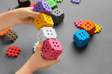 Child is playing with multi-colored blocks