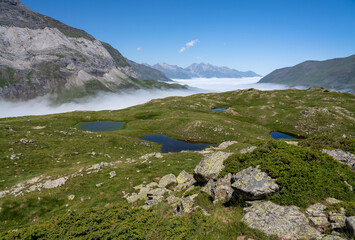 Fototapeta na wymiar mountain plateau and valley with cloud filling the valley below and clear blue summer sky
