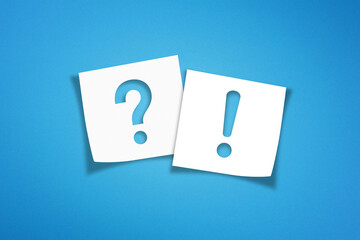 Note paper with exclamation mark and question mark on blue background