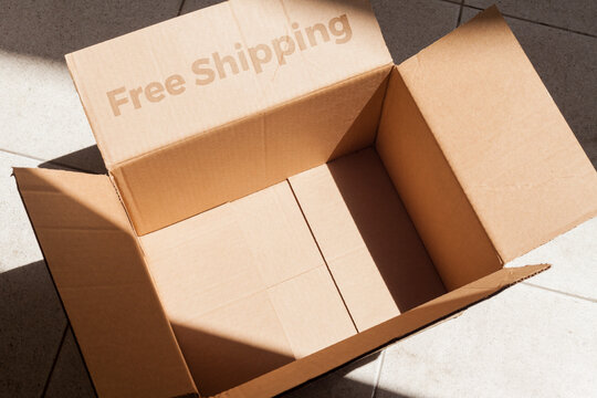 Open cardboard box with sunlight written on free shipping. Putting present inside the empty cardboard box. Box concept. Unboxing concept.