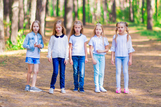 A group of five girls in the open air in the forest