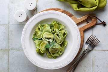 Top view of Tortelloni  or tortelli Balanzoni - italian green pasta with Spinach and Ricotta cheese filling, with butter and sage.