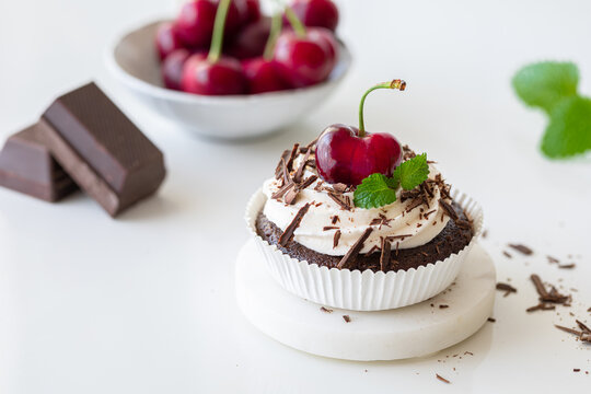 Chocolate Cherry cupcake white green leafes red. High quality photo