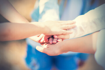 A group of girls walking in the summer forest put their hands together. The concept of friendship and unity. Team spirit