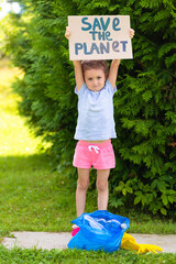 Girl collection plastic garbage in nature. kid picking up trash in park. Earth Day April 22. Child with plate Save the planet.  cleaning environment from rubbish pollution. World Environment Day