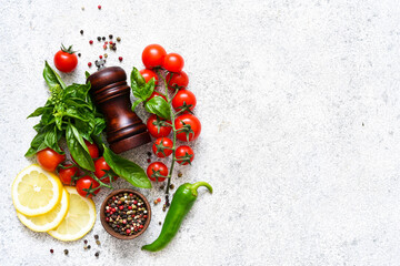 Obraz na płótnie Canvas Pepper grinder, basil, cherry tomatoes on a white background with space for text. Food ingredients.