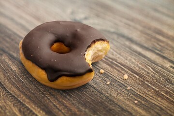 Sweet tasty chocolate glazed donut on the desk