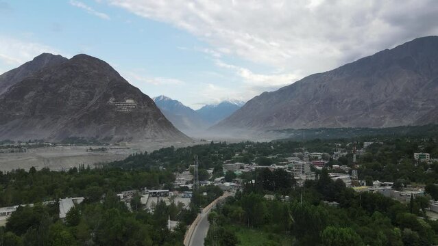 An aerial panorama of Danyor city before Gilgit City with blue sky and some clouds over the city skyline, Gilgit Baltistan Province, Pakistan. 