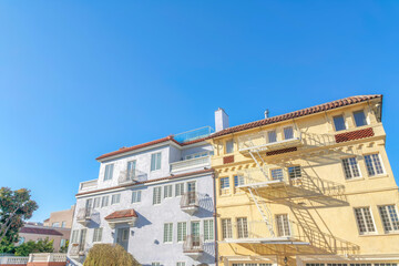 Two adjacent apartment buildings with clay roof tiles at San Francisco, CA