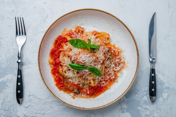 Pomodoro fettuccine with tomatoes on plate on white concrete table top view