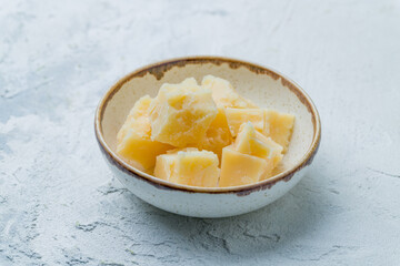 sliced Parmesan macro on bowl on white concrete table