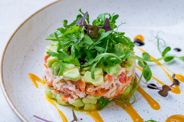 crab tartare with avocado and aragula on plate macro close up