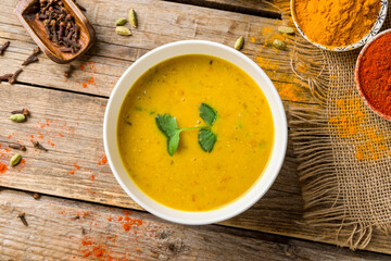 Spicy Lentil Soup on bowl, indian cuisine on old wooden table top view