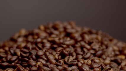 Heap roasted coffee beans close up. Super slow motion view brown coffee seeds.
