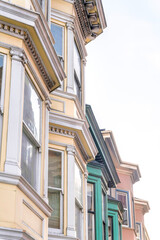 Bay windows of victorian townhouses against the white sky background at San Francisco, CA