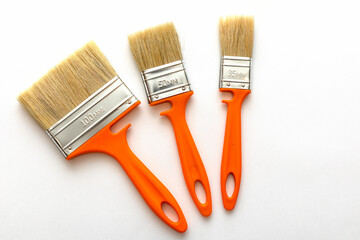 New paint brush with orange handle isolated on white background, close up. Set