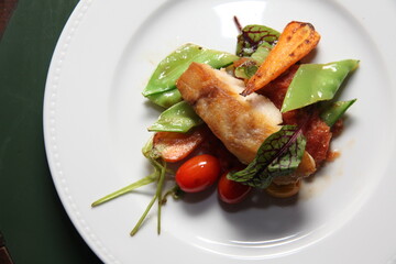 grilled fish and vegetables dish top view close up