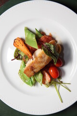 grilled fish and vegetables dish top view close up