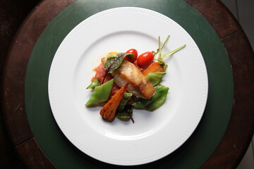 grilled fish and vegetables dish top view close up