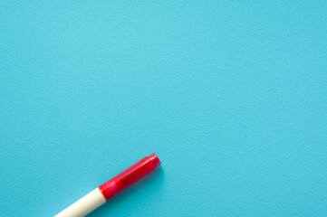 The creative concept of creativity is empty. A single red marker for marking lie off the edge of the blue kraft background. Back to school. Medical Notes. In aquamirin tones. Recipe