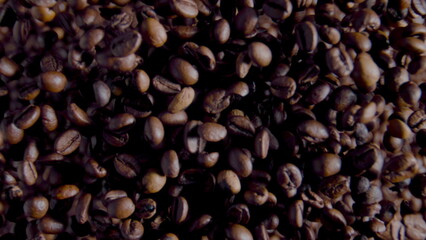 Process grinding coffee grains close up. Top view rotating fresh aromatic beans