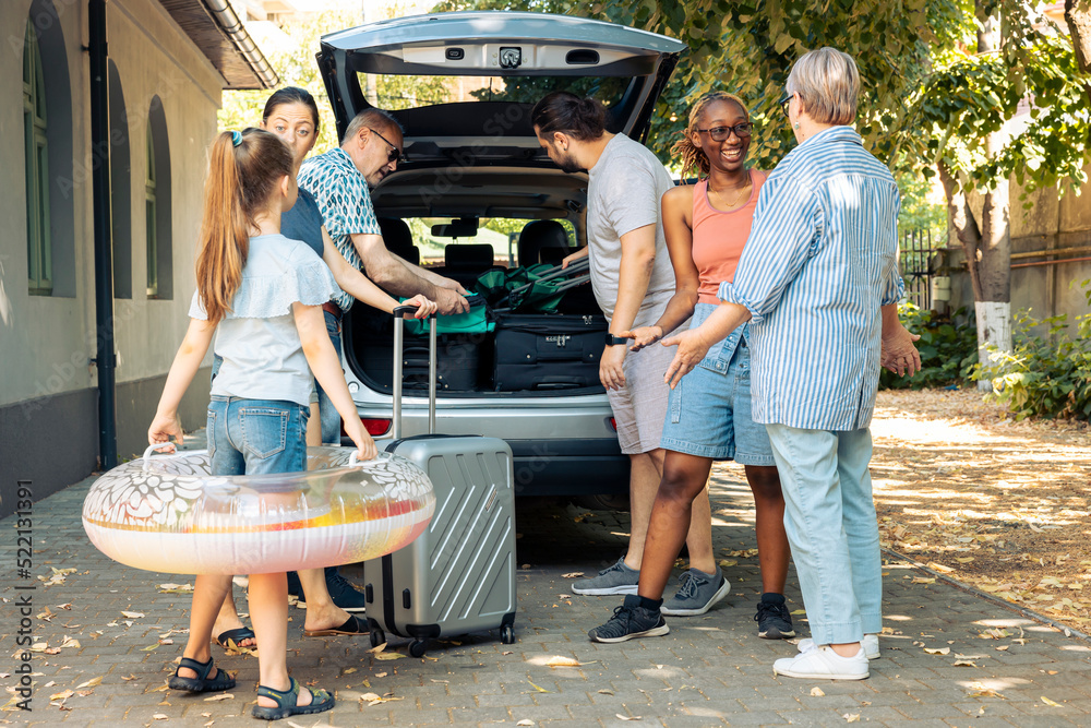 Wall mural multiethnic family and friends travelling on vacation, preparing to leave on summer holiday and load