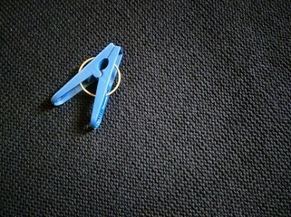 Blue plastic clothes pegs isolated by black background