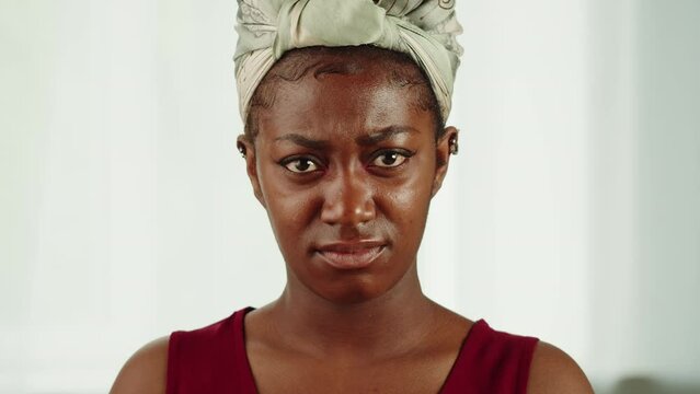 Unhappy African American woman portrait. Young female sad person close-up. Model posing, looking at camera.