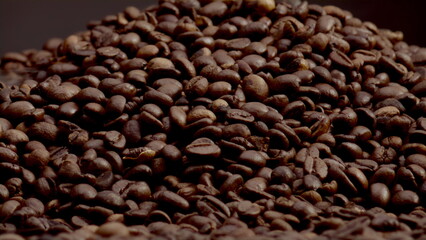 Textured coffee grains background closeup. Light steam coming from roasted seeds
