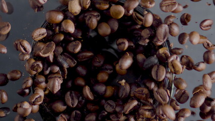 Roasted coffee beans spin in grinder top view closeup. Process preparation beans