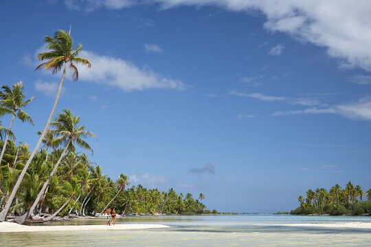 Couple walking in swimsuits on tropical beach island holding hands