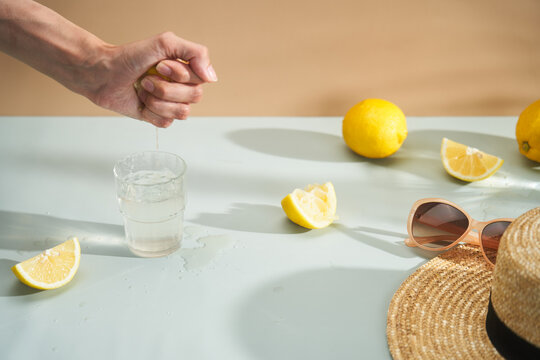 Squeezing lemon into glass of water