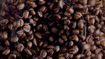 Fragrant coffee grains grinding in electric grinder top view close up.